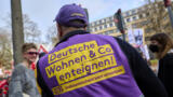 Mann trägt eine Weste mit der Aufschrift "Deutsche Wohnen & Co. enteignen"