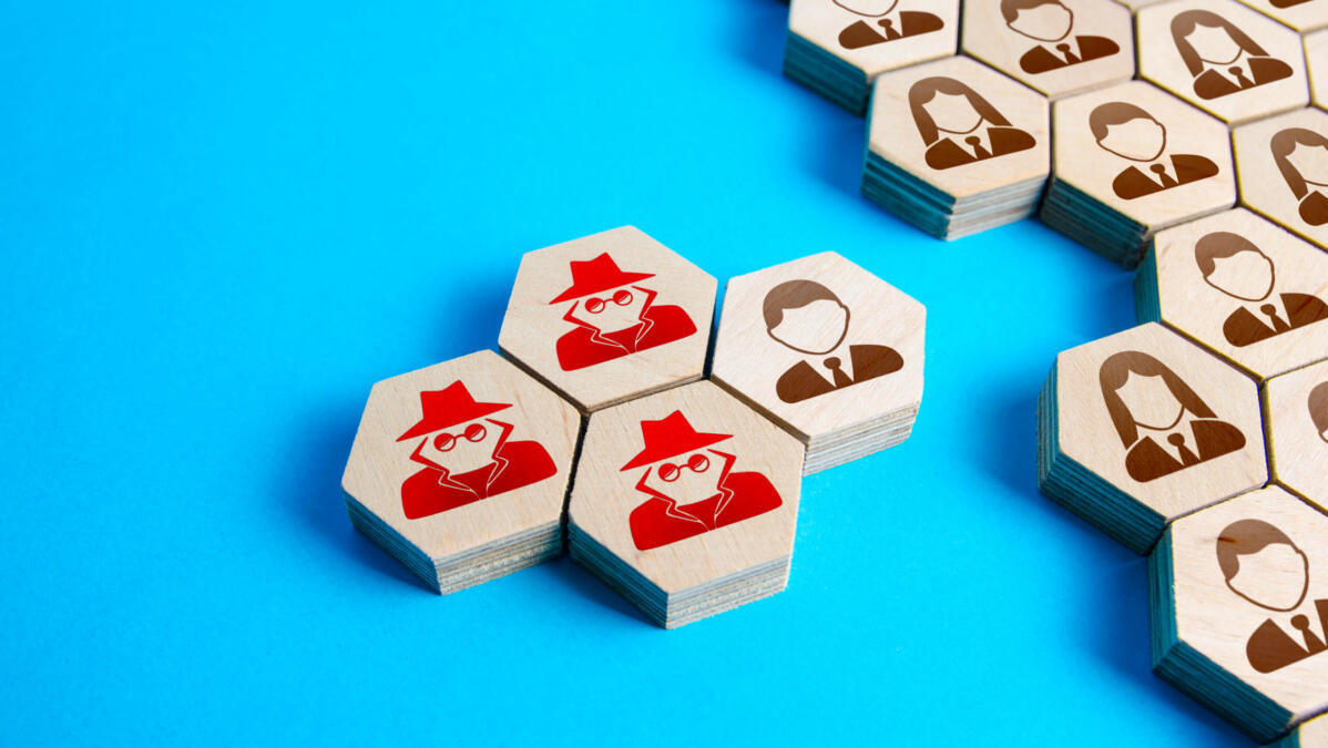 Spielsteine eines fiktiven Spiels, bei dem Spielsteine mit Agenten einen Spielstein einer Person umringen.