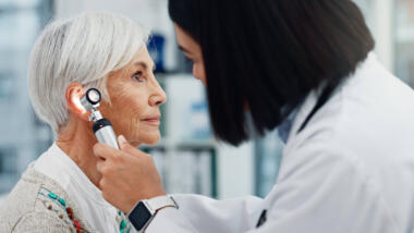 Eine Ärztin untersucht das Ohr einer Patientin.