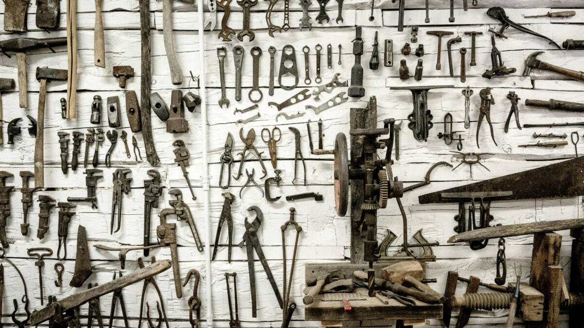 Eine weiße Wand, an der zahlreiche Werkzeuge hängen