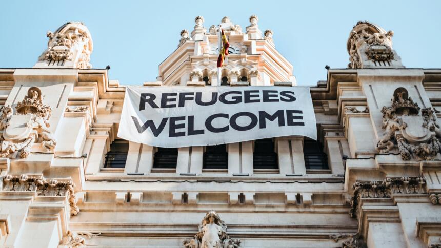Ein Banner mit "Refugees Welcome" an einem Haus
