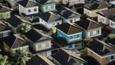 Mehrere gleichförmige Häuser. Eines sticht durch eine blaue Farbe hervor, der Rest ist leicht verschwommen.