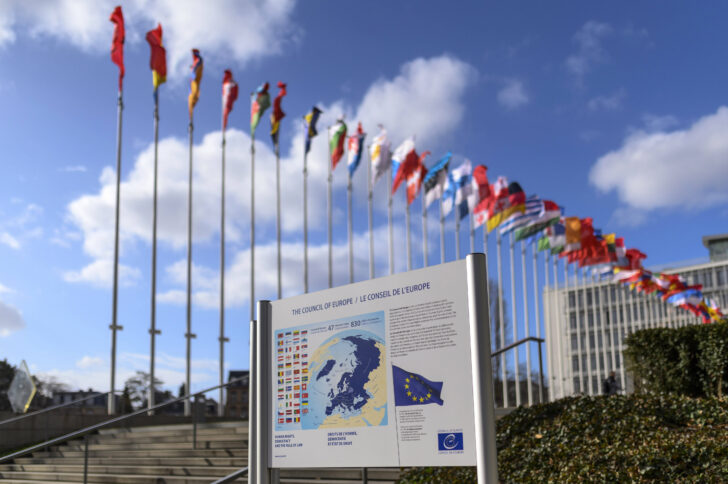 Reihe bunter Flaggen vor blauem Himmel