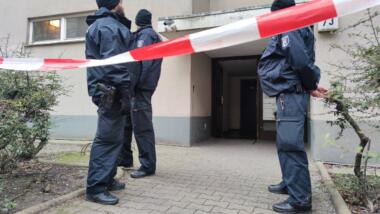 Drei Berliner Polizisten stehen vor dem Hauseingang, wo Klette gewohnt hatte