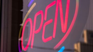 das Wort "Open" als Leuchtschriftzug in einem Schaufenster