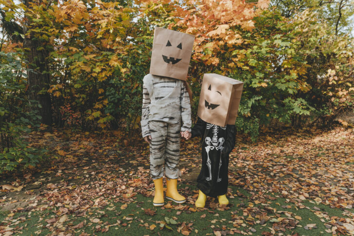 Zwei Kinder mit Tüten über dem Kopf.