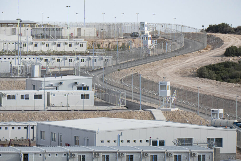 Weiße Container, daneben Stacheldrahtzaun