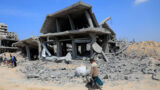Ein Mensch geht an einem zerstörten Gebäude im südlichen Gazastreifen vorbei