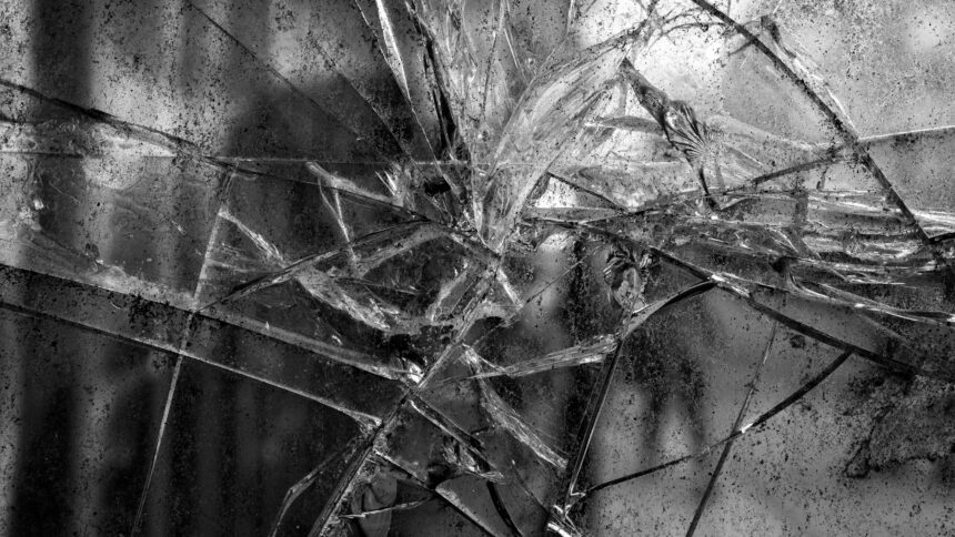 Schwarz-weiß-Aufnahme einer Glasscheibe mit vielen Rissen