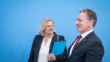 Nancy Faeser und Holger Münch vor einem blauen Hintergrund.