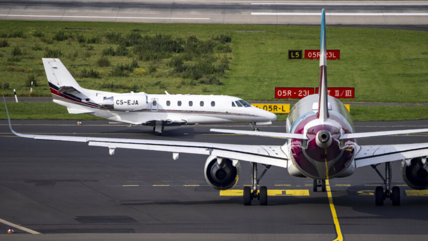 Ein Cessna-Privatflugzeug kreuzt den Weg eines größeren Passagierflugzeugs an der Landebahn auf dem Flughafen Düsseldorf