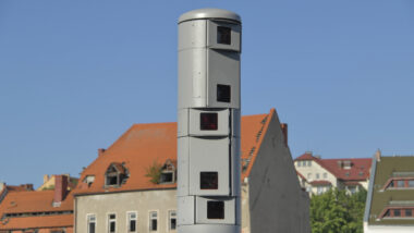 Überwachungskamerasäule, im Hintergrund ein Haus