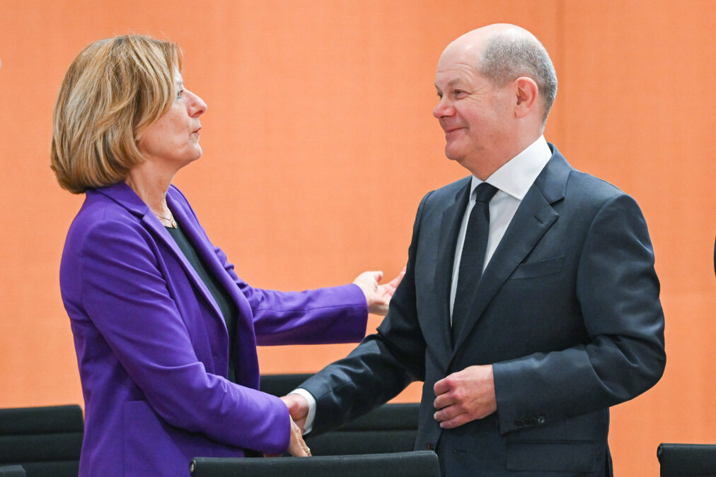 Mensch im blauen Blazer links, Mensch im schwarzen Anzug rechts, sie schütteln sich die Hand
