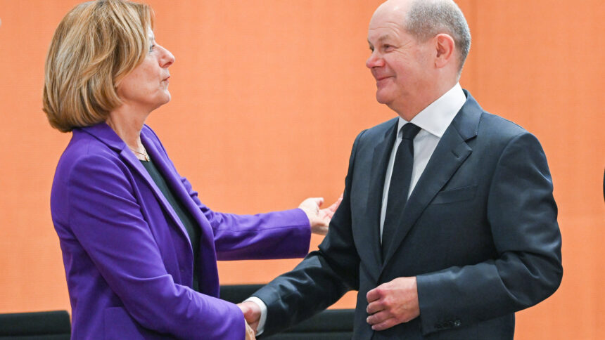 Mensch im blauen Blazer links, Mensch im schwarzen Anzug rechts, sie schütteln sich die Hand