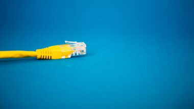 Ein LAN Kabel in Gelb vor blauen Hintergrund