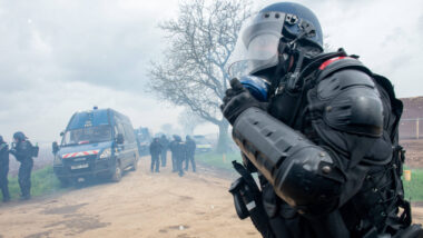 Ein gepanzerter Polizist mit Gasmaske