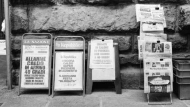 Ein schwarz-weiß-Foto von Zeitungsaufsteller mit verschiedenen großen Zeitungen