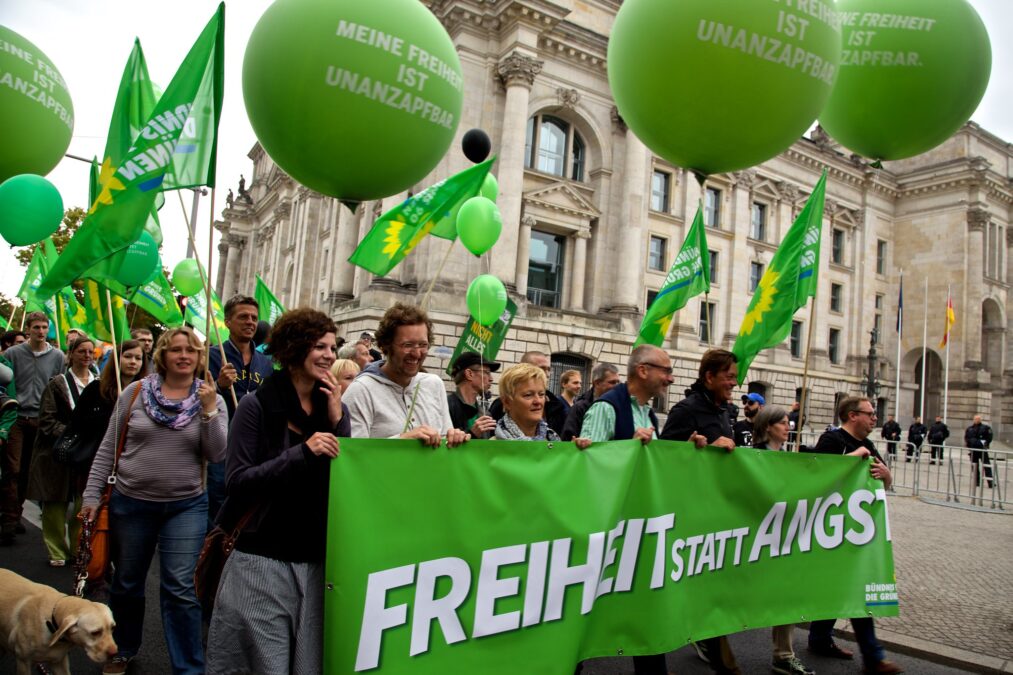 Grüne mit Parteifahnen, Luftballons und Transparent "Freiheit statt Angst" bei einer Demo