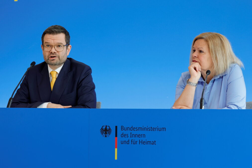 Zwei Personen vor blauem Hintergrund