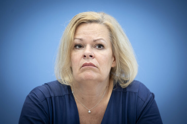 Porträt einer blonden Frau vor blauem Hintergrund