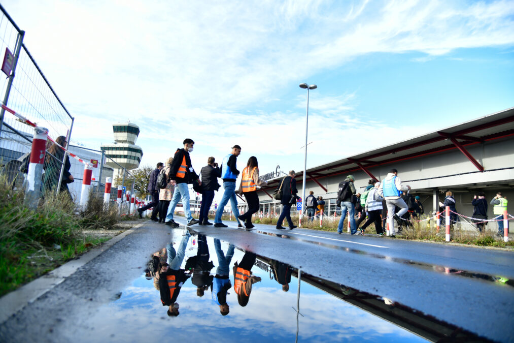 Menschen überqueren eine Straße am Flughafen Tegel