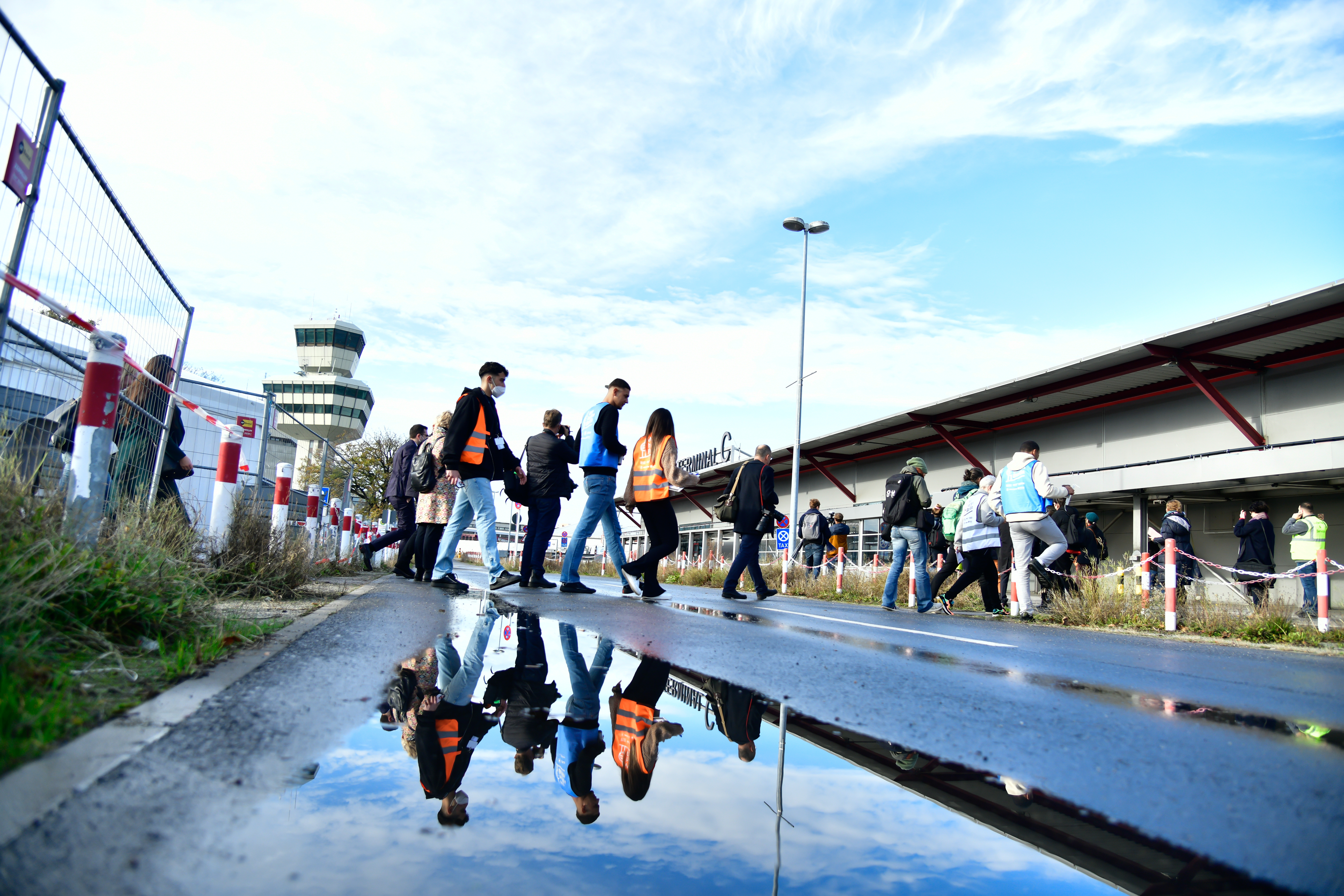 Menschen überqueren eine Straße am Flughafen Tegel