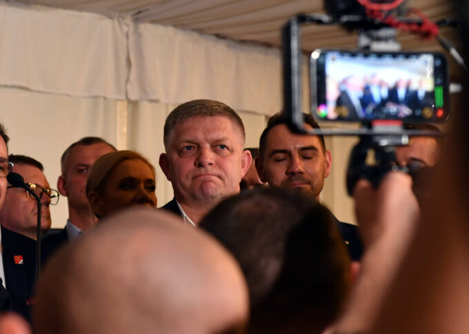 Bild von einer Menschenmenge, dahinter Mann, der gefilmt wird