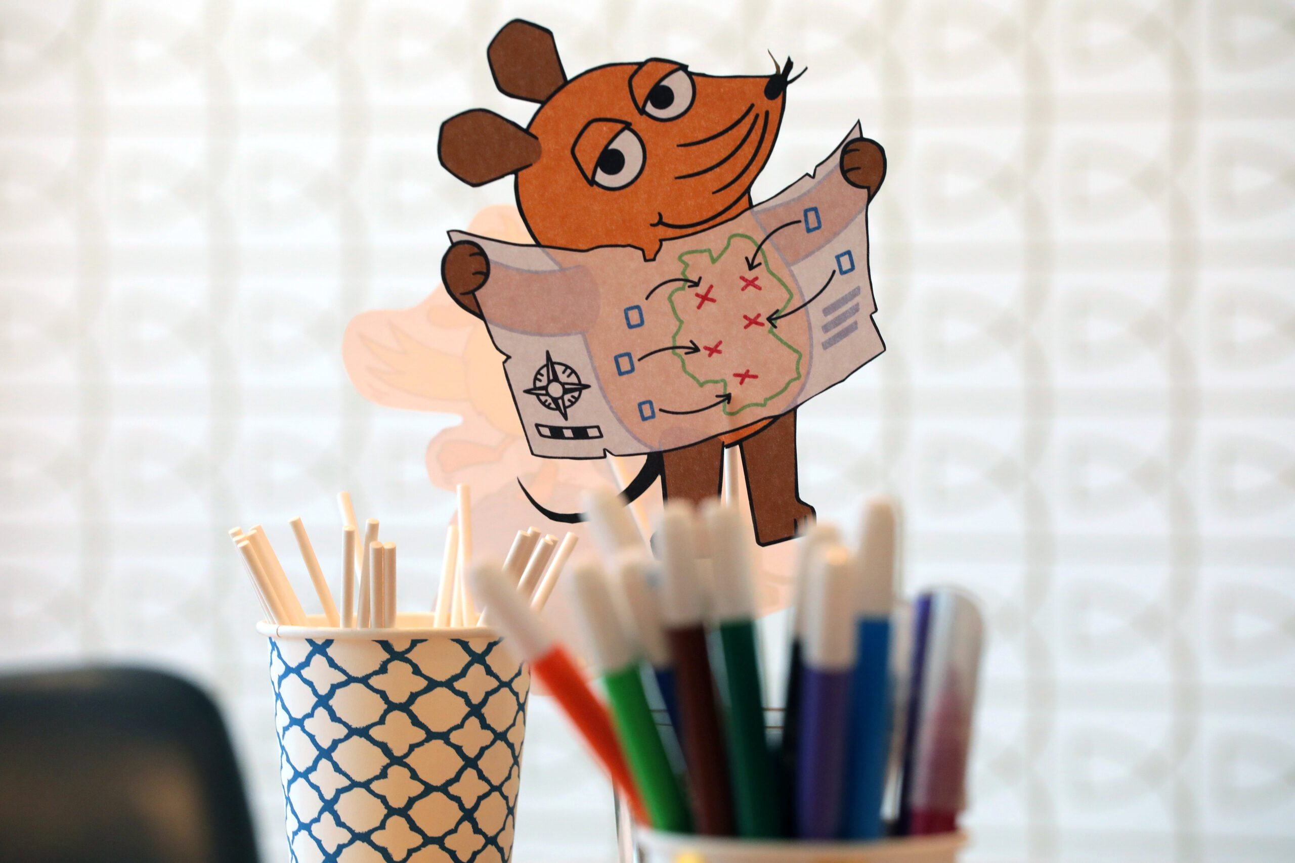 Eine Maus-Figur steckt in einem Stiftebecher