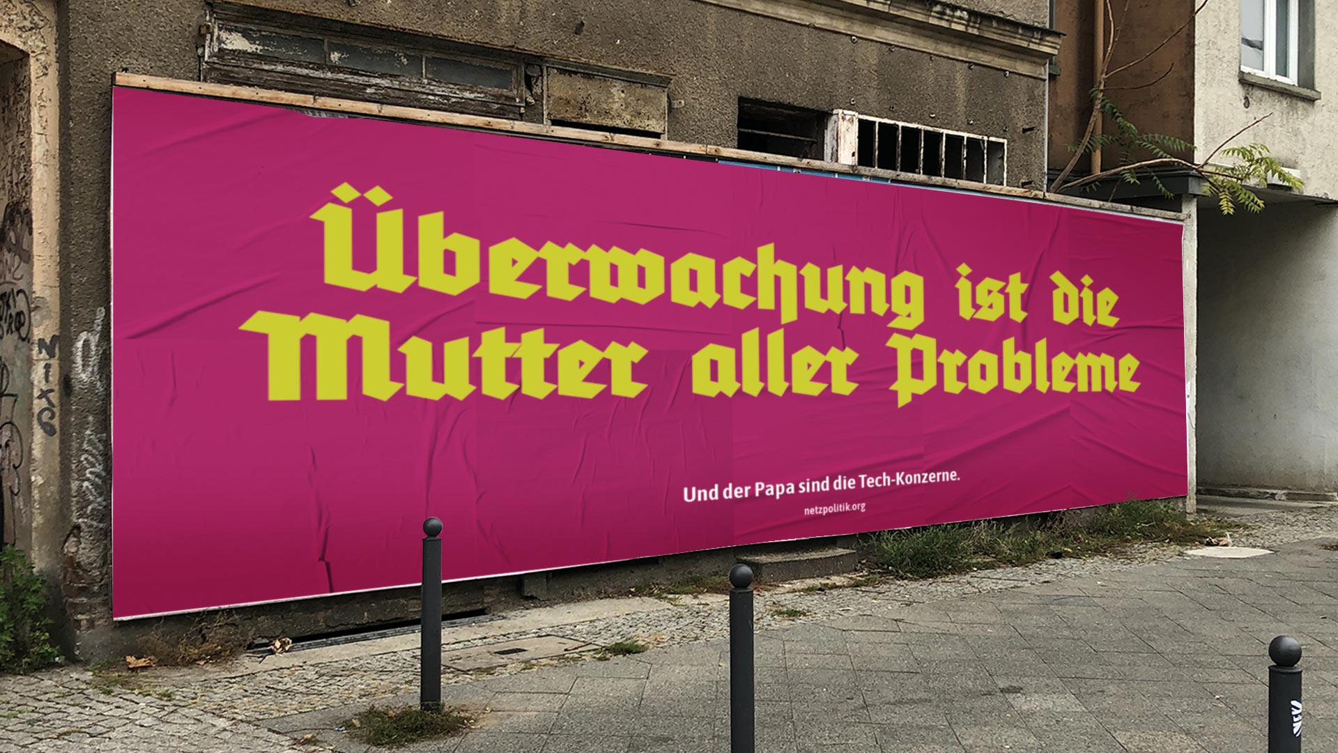 Eine Werbefläche vor einer Hauswand mit der Aufschrift "Überwachung ist die Mutter aller Probleme"