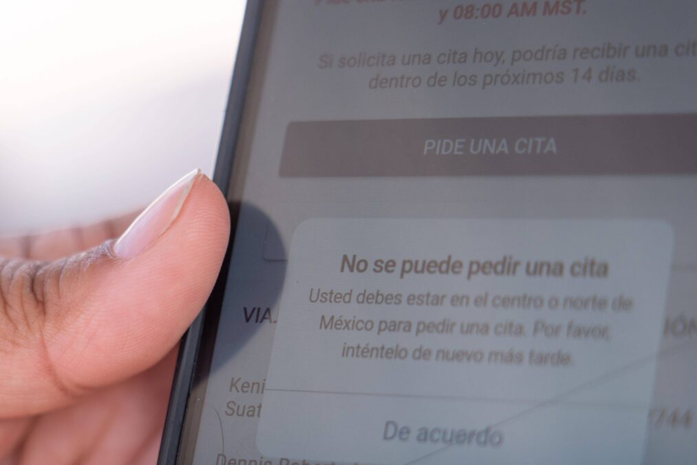 Person hält Handy mit geöffneter CBP One App in der Hand