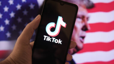 Telefon mit Tiktok-Logo vor Trump-Porträt