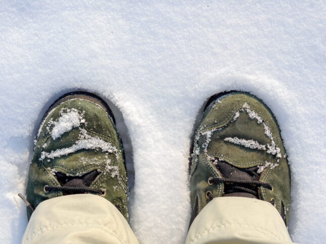 Grüne Schuhe stehen im Schnee