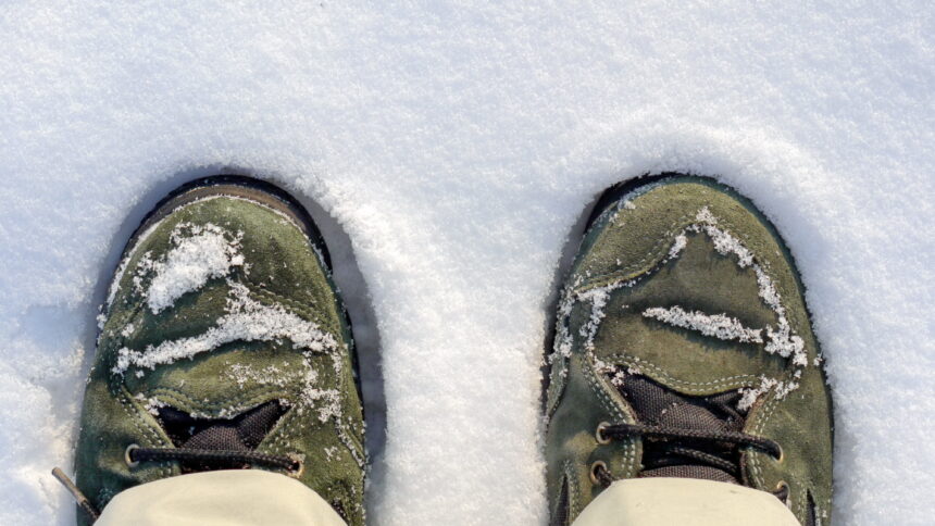 Grüne Schuhe stehen im Schnee