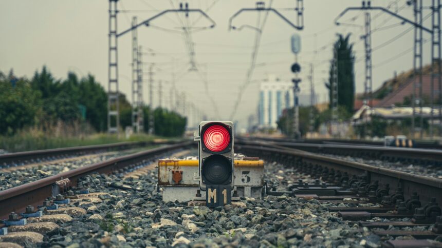 Ein rotes Leuchtsignal zwischen zwei Gleisen auf dem Gleisbett