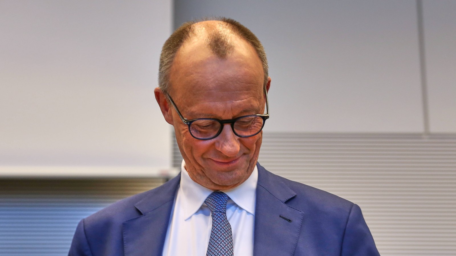 Friedrich Merz schaut nach unten und freut sich offenbar klammheimlich
