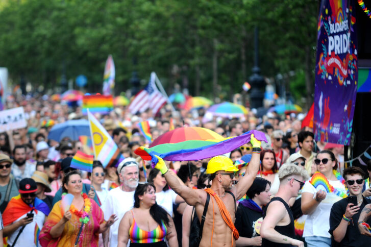 Eine Menschenmenge mit Regenbogenfahnen auf der Straße