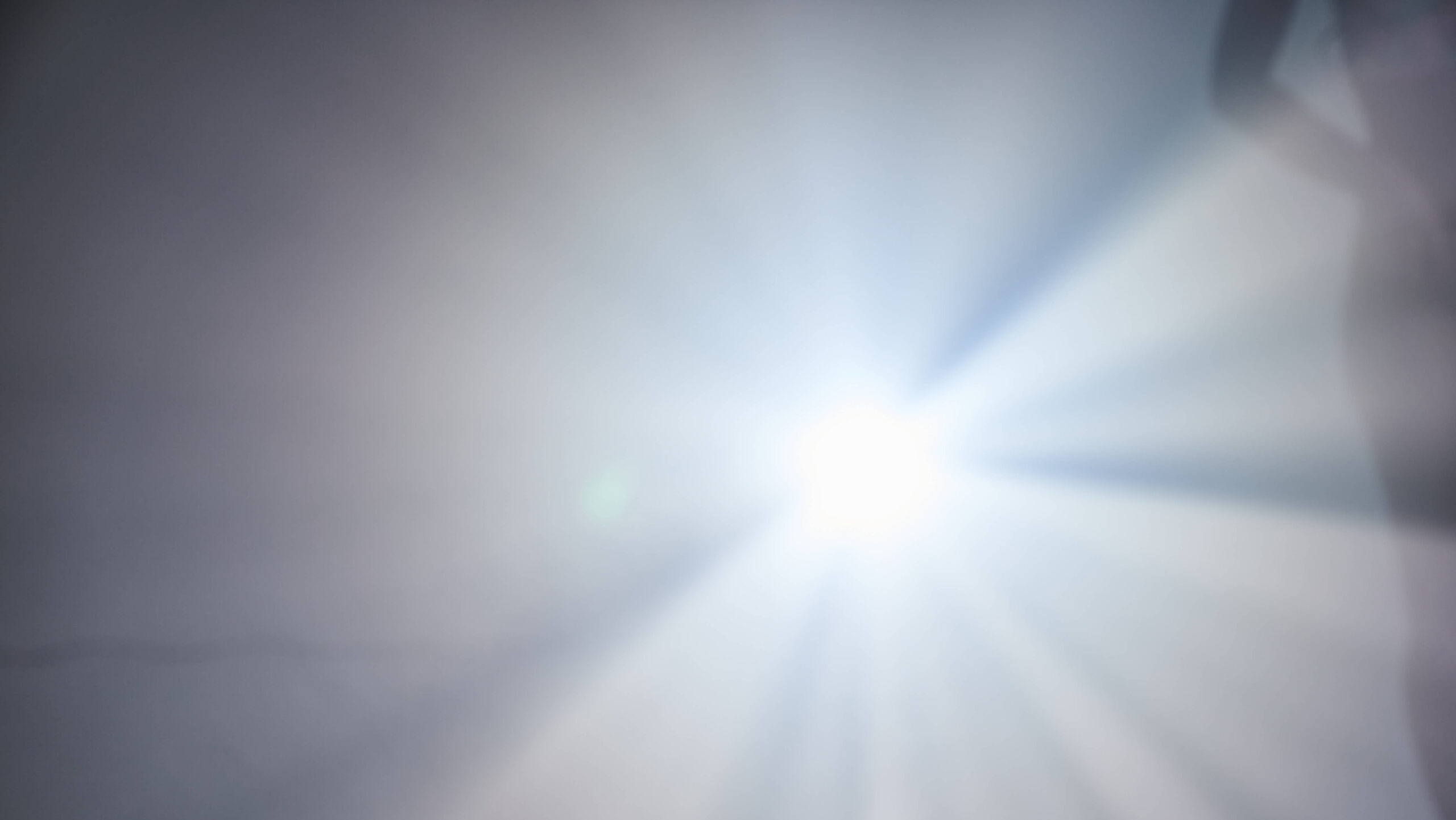 Man sieht ein blendendes Licht, am Rand die Silhoutte eines Menschen