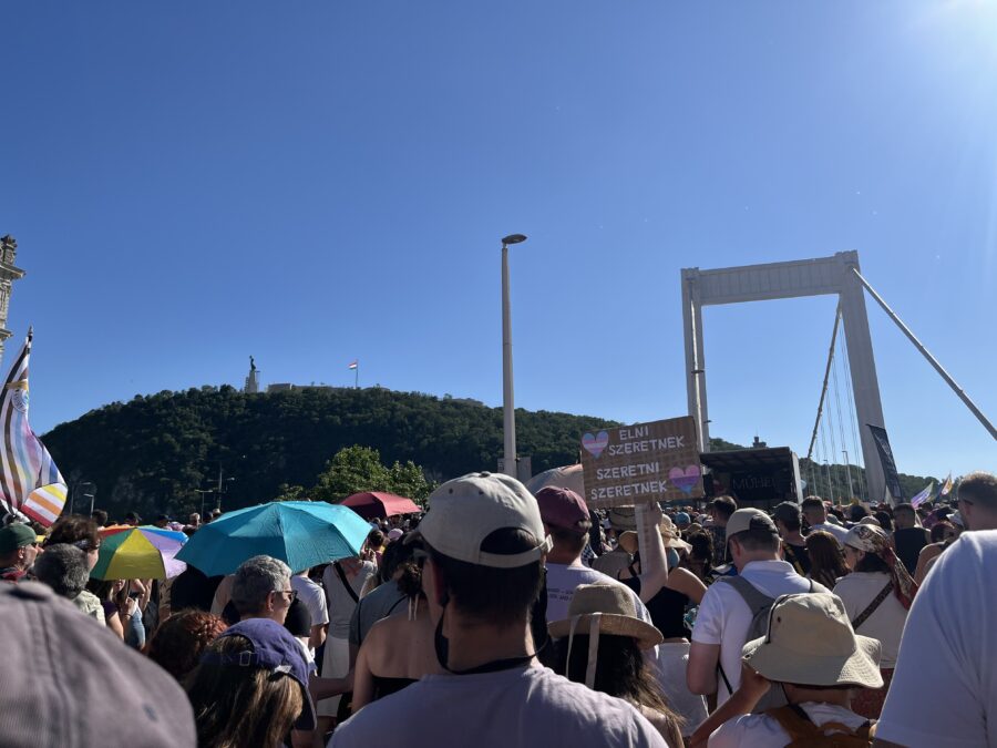 Menschen auf der Brücke vor einem Hügel
