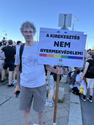 Mensch in weißem T-Shirt mit Demoschild