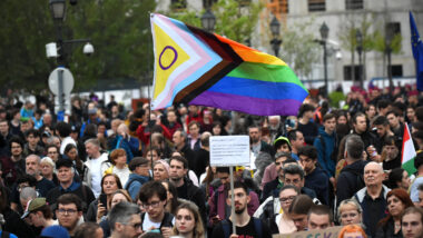 Menschen marschieren mit Regenbogen-Flagge