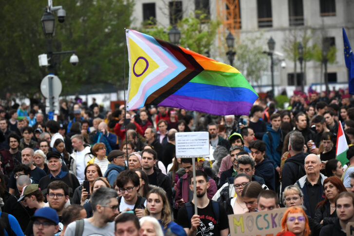 Menschen marschieren mit Regenbogen-Flagge