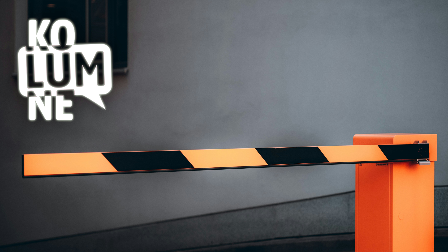 Eine Schranke mit schwarz-orangenen Streifen, die auf einer Straße steht.