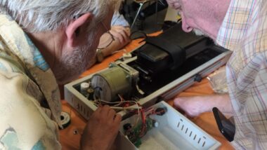 Zwei Männer beugen sich über ein technisches Gerät.