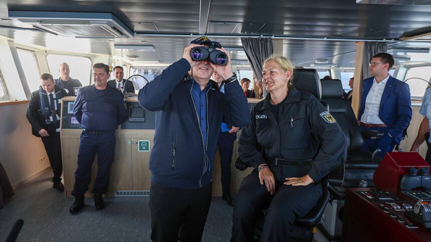 Innenminister Dobrindt guckt durch Fernglas.