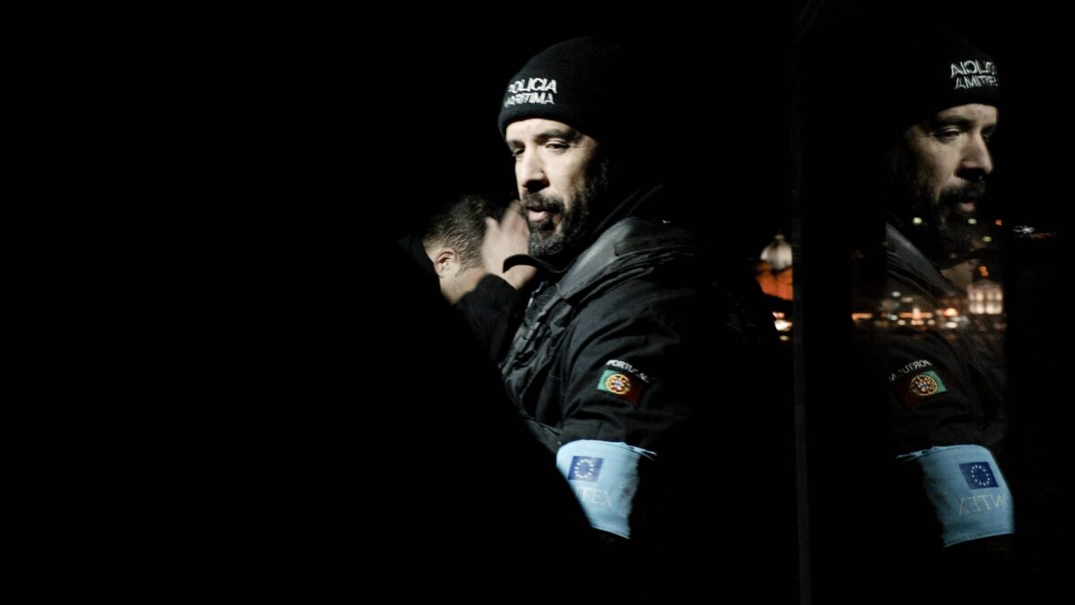 Polizist mit Frontex-Armbinde in der Nacht