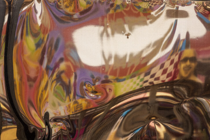 Zerrspiegel reflektiert buntes Wandbild