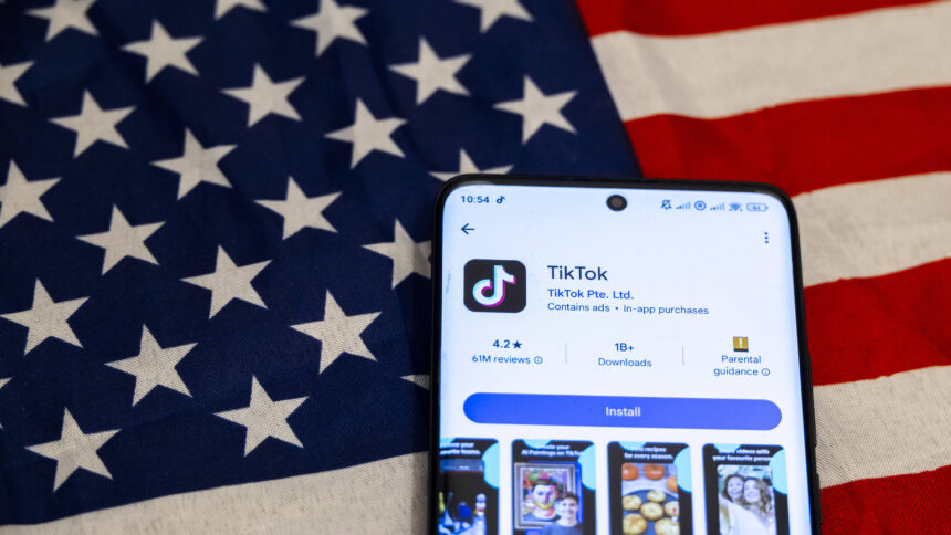 Smartphone liegt auf USA Fahne, TikTok wird im Appstore angezeigz