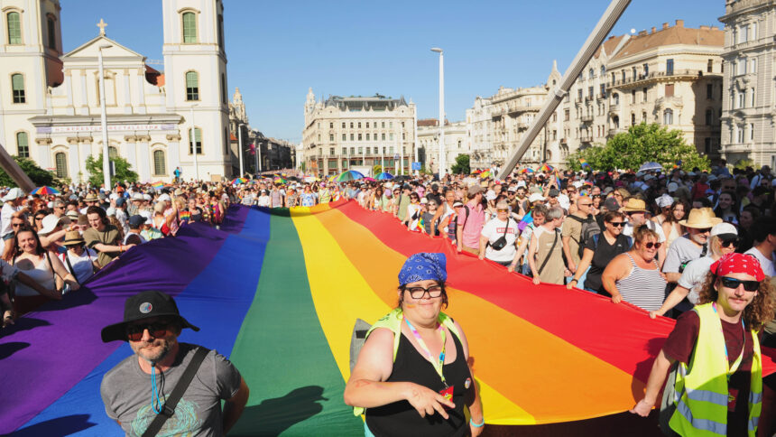 Menschen tragen ein Regenbogenbanner auf einer Demo