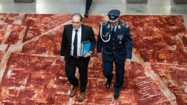 Dobrindt von oben fotografiert, begleitet von einem Menschen in Uniform