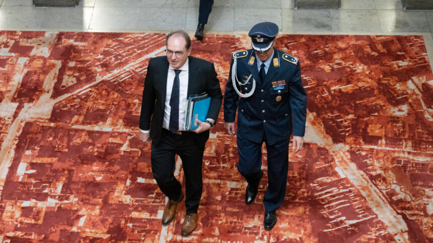 Dobrindt von oben fotografiert, begleitet von einem Menschen in Uniform